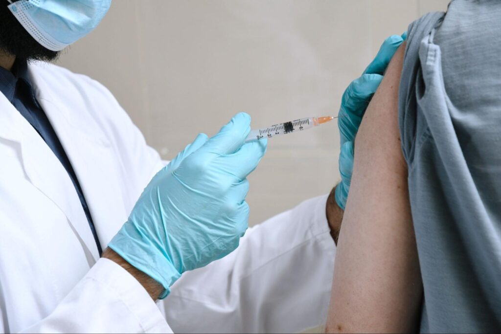Doctor administering a vaccine into the arm of a patient.