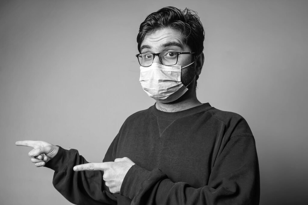 man, face mask, pointing, gesture, hand gesture, eyeglasses, young man, male, person, healthcare, sickness, flu, epidemic, coronavirus, covid-19, pandemic, portrait-5888549.jpg